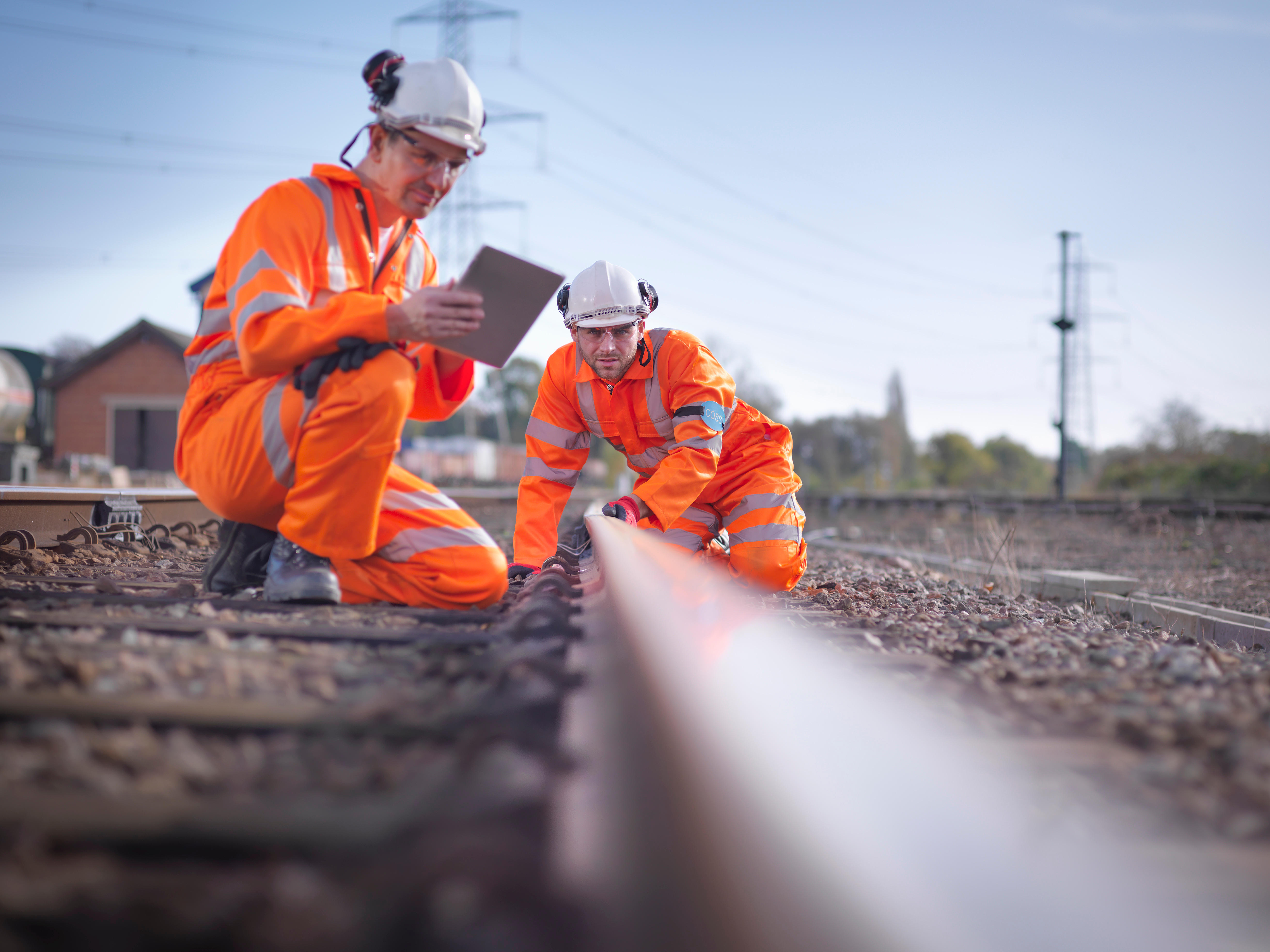 Railway maintenance workers using digital tablet to inspect track