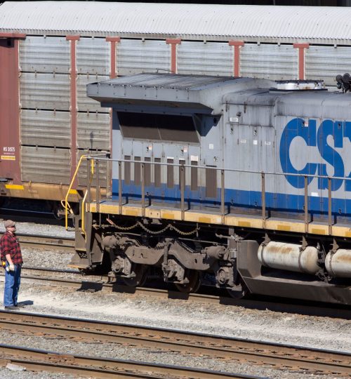 B4NT64 A CSX employee waits as a freight train passes behind his locomotive at the Selkirk NY rail yard.