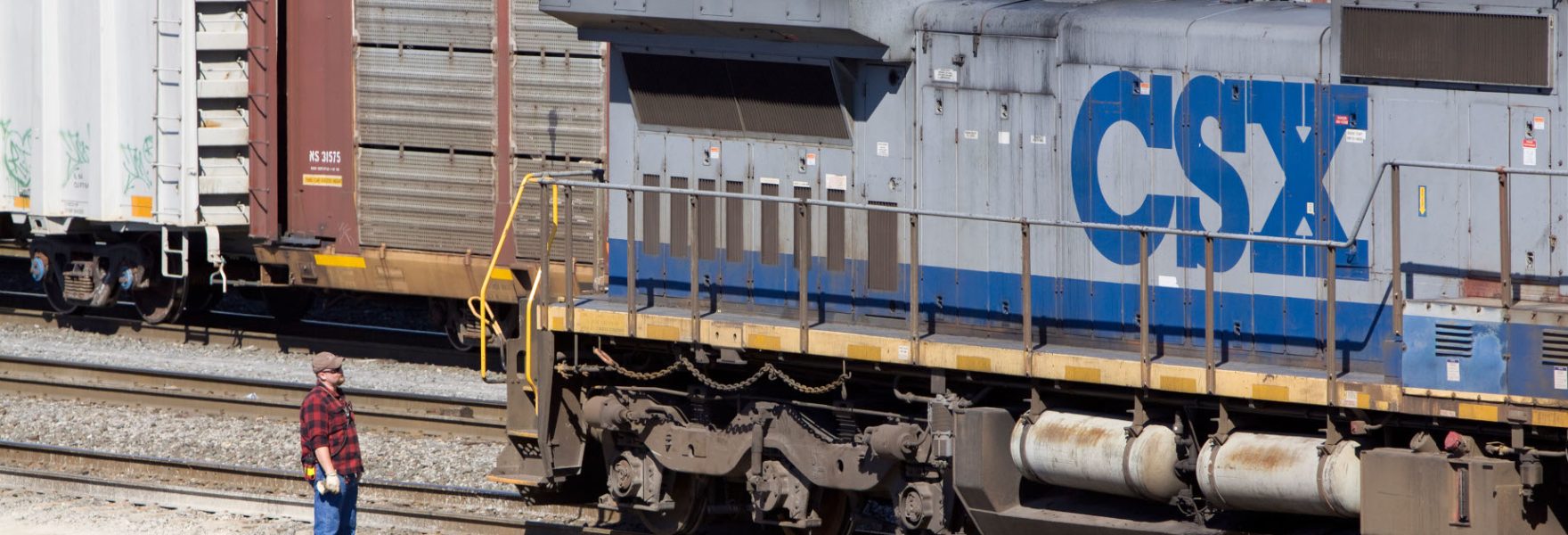 A CSX employee waits as a freight train passes behind his locomotive at the Selkirk NY rail yard. B4NT64 A CSX employee waits as a freight train passes behind his locomotive at the Selkirk NY rail yard.